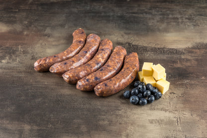 Rohe Salsiccia im Naturdarm mit sichtbaren Blaubeeren im groben Brät, von der Seite fotografiert